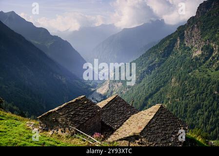 Naturpark Valsesia und das Hochtal Strona mit Blick über das Tal mit Steindächern traditioneller Hütten im Vordergrund, Piemont Stockfoto