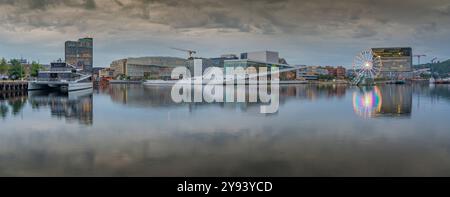 Blick auf das Opernhaus von Oslo und das Munch Museum, das sich am bewölkten Tag im Hafen spiegelt, Oslo, Norwegen, Skandinavien, Europa Stockfoto