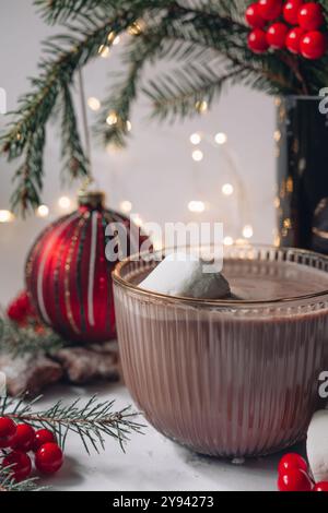 Heiße Schokolade in einem Glas mit Marshmallows auf einem Hintergrund von Bokeh-Lichtern, heißes Weihnachtsgetränk Stockfoto