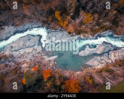 Atemberaubende Luftaufnahme des Ara-Flusses, der sich durch die lebhaften herbstlichen Wälder der aragonesischen Pyrenäen in Ordesa schlängelt, Huesca, die mächtige Kraft Stockfoto