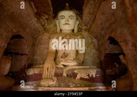 Antike sitzende Buddha-Statue mit Farbspuren in einem historischen Tempel in Pindaya, Myanmar. Stockfoto