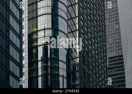 Aus nächster Nähe sehen Sie moderne New York City Wolkenkratzer mit reflektierenden Glasfassaden. Die Gebäude erzeugen ein fesselndes geometrisches Muster, hervorgehoben b Stockfoto