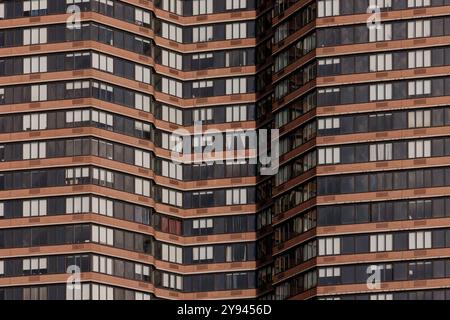 Dieses Bild zeigt eine Nahaufnahme eines modernen Hochhauses in New York City. Die symmetrische Anordnung von Fenstern und Balkonen zeigt Stockfoto