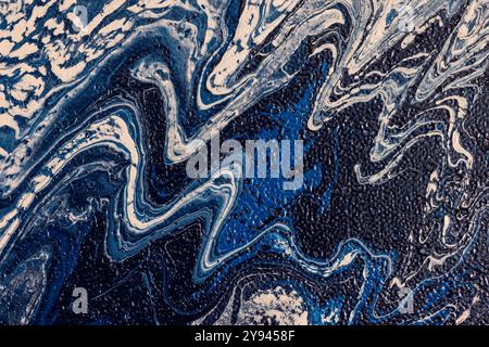 Dieses Bild zeigt eine atemberaubende abstrakte Marmor-Textur mit wirbelnden blauen, weißen und dunklen Akzenten. Die fließenden, wellenartigen Muster erzeugen ein Gefühl von Stockfoto