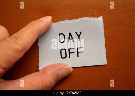 Tagesmeldung auf zerrissenem Papierstück auf braunem Hintergrund geschrieben. Konzeptionelles Symbol für freien Tag. Kopierbereich. Stockfoto