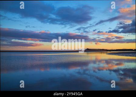 Sonnenuntergang über Montrose Beach mit seinen Sanddünen im Hintergrund, aufgenommen vom St Cyrus Beach bei Ebbe im Winter. Stockfoto