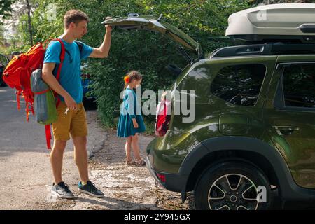 Eine aufregende Familie bereitet sich auf ein Abenteuer vor und packt das Auto für einen aufregenden gemeinsamen Tag Stockfoto