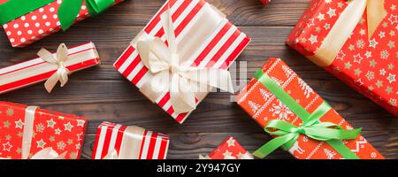 Viele Weihnachtsgeschenkschachteln in farbigem Papier auf dem Tisch dekoriert, Draufsicht aus der Nähe. Viele präsentieren Neujahrsgeschenk. Stockfoto