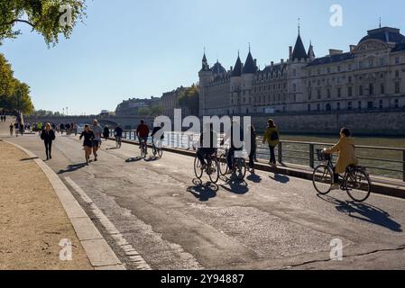 Paris, Frankreich, 10.05.2024 Radfahrer und Jogger genießen einen sonnigen Herbsttag entlang der seine mit der Conciergerie im Hintergrund Stockfoto