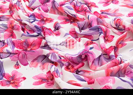 Farbenfroher Stoff mit Blumenmuster und Blumen im Aquarellstil in Rosa- und Lila-Tönen, Nahaufnahme Stockfoto