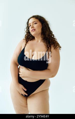 Eine schöne Frau in Übergröße zeigt selbstbewusst ihre Kurven und ihren einzigartigen Stil und strahlt Positivität aus. Stockfoto