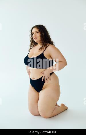 Eine schöne Frau in Übergröße zeigt ihr Selbstvertrauen mit einer ausgeglichenen Pose in einer minimalistischen Umgebung. Stockfoto