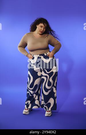 Eine selbstbewusste Frau in Übergröße zeigt ihren Sinn für Mode in leuchtend gemusterten Hosen und strahlt Freude aus. Stockfoto