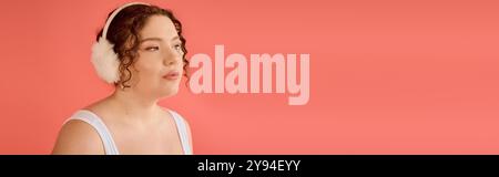 Eine atemberaubende Frau in Übergröße zeigt ihre Schönheit, trägt weiche Ohrenschützer und passt sich ihrem Stil an. Stockfoto