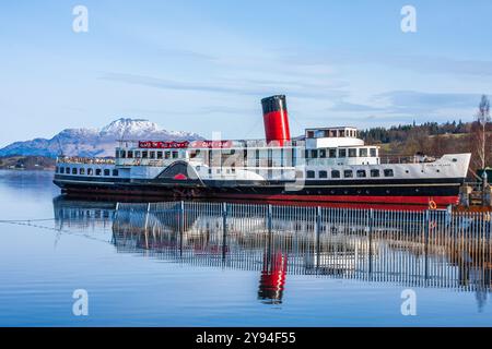 Der Raddampfer Maid of the Loch spiegelt sich in den stillen Gewässern des Loch Lomond mit Schnee auf dem Gipfel des Ben Lomond an einem frischen Wintertag. Stockfoto