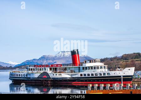 Der Raddampfer Maid of the Loch spiegelt sich in den stillen Gewässern des Loch Lomond mit Schnee auf dem Gipfel des Ben Lomond an einem frischen Wintertag. Stockfoto