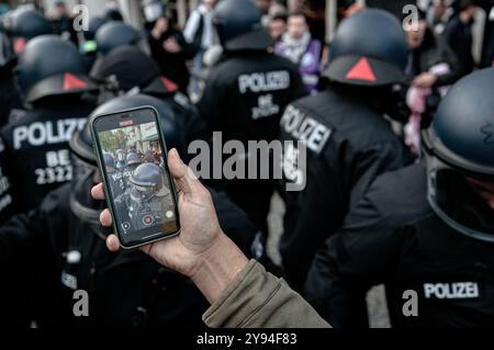 Berlin, Deutschland. Oktober 2024. Eine Person nimmt ein Video auf, in dem pro-palästinensische Demonstranten während eines Protests für palästinensische Rechte am ersten Jahrestag der Hamas-Invasion in Südisrael in Berlin mit der deutschen Polizei zusammenstoßen. Der Protest unter dem Motto „Glory to the Resistance“ wurde von einer großen Polizeipräsenz begleitet. Am 7. Oktober 2023 stürmten Tausende von Hamas-Militanten vom Gazastreifen nach Israel, töteten 1.139 Menschen und entführten Israelis. Quelle: SOPA Images Limited/Alamy Live News Stockfoto