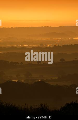 Atemberaubende Aussicht von den Quantock Hügeln kurz vor Sonnenaufgang mit Blick ins Landesinnere in Richtung Südosten mit Schichten von sanften Hügeln, Bäumen und niedrig liegenden Nebel Stockfoto