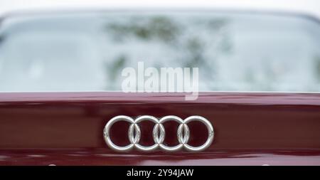 Nahaufnahme des Audi-Logos auf einem braunen Auto mit dem ikonischen Emblem der Marke mit verschwommenem Hintergrund, ideal für Automobile, Branding. Stockfoto