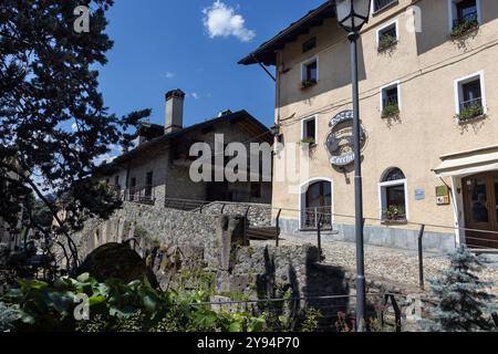 AOSTA, ITALIEN, 1. AUGUST 2024: Malerische alte römische Steinbrücke (Ponte di Pietra) in der Altstadt von Aosta. Die Brücke stammt aus dem Jahr 24 v. Chr. und ist ein Touristenziel Stockfoto