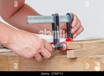 Befestigung von Schreinerklammern an einem Holzgestell in einer Schreinerei, Verkleben von Brettern Stockfoto