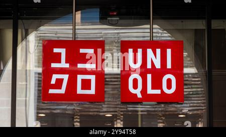 Uniqlo Doppelschild mit japanischem und westlichem Logo am Eingang eines Geschäfts. Uniqlo ist eine Marke des japanischen Bekleidungskonzerns Fast Retailing Stockfoto