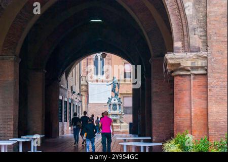 Der Blick auf den Neptunbrunnen durch den gewölbten Pass im Palazzo Re Enzo, Bologna, Italien Stockfoto