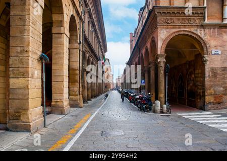 Via Zamboni Straße mit geparkten Fahrrädern entlang der Arkaden der Basilika San Giacomo Maggiore, Bologna, Italien Stockfoto