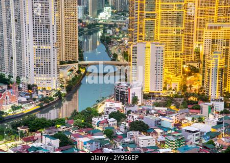 Manila, Luzon, die Philippinen-19. Mai 2023: Streifenlichter, die die hohen Strukturen der Wohnung und des Geschäftsviertels abdecken, sind in der Abenddämmerung eingeschaltet Stockfoto