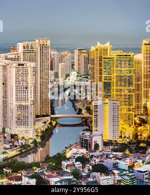 Manila, Luzon, die Philippinen-19. Mai 2023: Streifenlichter, die die hohen Strukturen der Wohnung und des Geschäftsviertels abdecken, sind in der Abenddämmerung eingeschaltet Stockfoto