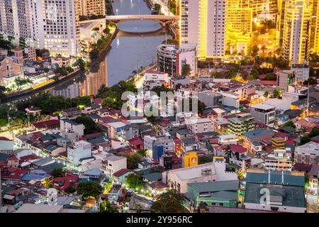 Manila, Luzon, die Philippinen-19. Mai 2023: Streifenlichter, die die hohen Strukturen der Wohnung und des Geschäftsviertels abdecken, sind in der Abenddämmerung eingeschaltet Stockfoto