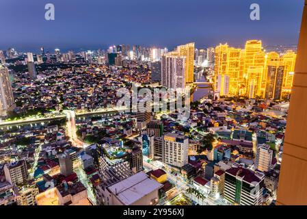 Manila, Luzon, die Philippinen-19. Mai 2023: Streifenlichter, die die hohen Strukturen der Wohnung und des Geschäftsviertels abdecken, sind in der Abenddämmerung eingeschaltet Stockfoto