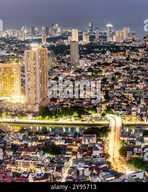 Manila, Luzon, die Philippinen-19. Mai 2023: Streifenlichter, die die hohen Strukturen der Wohnung und des Geschäftsviertels abdecken, sind in der Abenddämmerung eingeschaltet Stockfoto