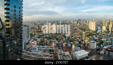 Manila, Philippinen-16. Mai 2023: Der Pasig River fließt bei Sonnenuntergang durch die Hauptstadt, umgeben von einer Mischung aus hoher moderner Architektur und armen Wohnhäusern Stockfoto