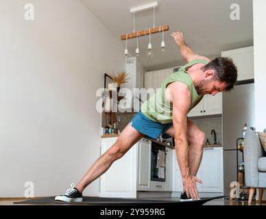 Männlicher Sportler, der zu Hause anaerobe Workouts macht. Aktiver Lebensstil. Stockfoto