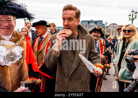 Hollywood-Schauspieler Damian Lewis isst Einen Donut zum Frühstück, bevor er den Annual Sheep Drive über die Southwark Bridge in London führt. Stockfoto