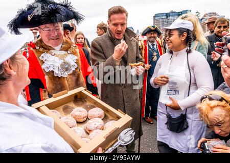 Hollywood-Schauspieler Damian Lewis isst Einen Donut zum Frühstück, bevor er den Annual Sheep Drive über die Southwark Bridge in London führt. Stockfoto