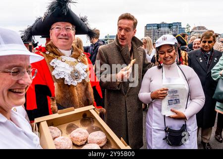 Hollywood-Schauspieler Damian Lewis isst Einen Donut zum Frühstück, bevor er den Annual Sheep Drive über die Southwark Bridge in London führt. Stockfoto