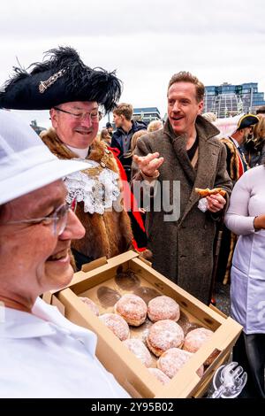 Hollywood-Schauspieler Damian Lewis isst Einen Donut zum Frühstück, bevor er den Annual Sheep Drive über die Southwark Bridge in London führt. Stockfoto