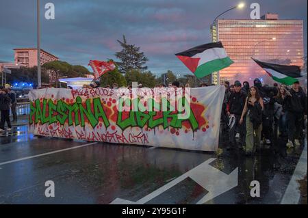 Rom, Italien. Oktober 2024. Studenten von Kollektiven, die die palästinensische Sache unterstützen, schwenken die palästinensische Flagge und marschieren mit einem Banner mit der Aufschrift "˜von Schulen zu Universitäten auf die Straßen unserer Stadt, freies Palästina" während eines Protestes gegen Unternehmen, die mit Israel zusammenarbeiten, die sich auf der Konferenz "Cybertech Europe 2024" in Rom versammelt haben. Ein paar Dutzend Studenten der Studentenkollektive für Palästina hatten ihre Absicht zum Ausdruck gebracht, vor dem Fuksas Nuvola Congress Center zu marschieren, wo die „Cybertech Europe 2024“-Konferenz stattfindet, mit der Participa Stockfoto