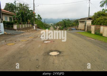 Viele Schlaglöcher auf einer unbefestigten Straße in einem Wohnviertel in Schroeder, Santa Catarina, Brasilien Stockfoto