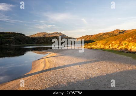 Das Abendlicht leuchtet an den sandigen Ufern der Mündung des Afon Dwyryd River unter den Hügeln von Snowdonia in Nordwales. Stockfoto