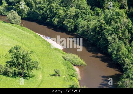 Kajakfahrer ruhen sich an einem kleinen Strand in einer Mäander des Flusses Wye bei Welsh Bicknor in Herefordshire, England aus. Stockfoto