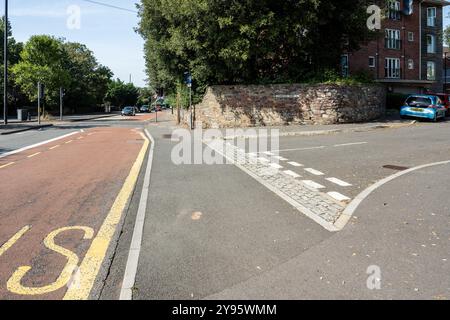 Ein durchgehender Fußweg mit angehobenem Tisch bildet eine verkehrsberuhigende und Fußgängerpriorität über eine Seitenstraße eines Wohngebäudes auf einem Stockfoto