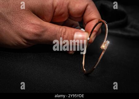 Ein wunderschön gefertigter Diamant-Armreif mit zartem Roségold-Rahmen, der sorgfältig von Hand gehalten wird. Dieses luxuriöse Armband ist perfekt für einen Hauch von Stockfoto