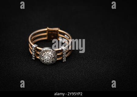 Ein luxuriöser runder Diamant-Cluster-Ring in Gold mit einem strahlenden zentralen Diamanten, umgeben von kleineren Diamanten. Dieses elegante Stück ist ein Perfec Stockfoto