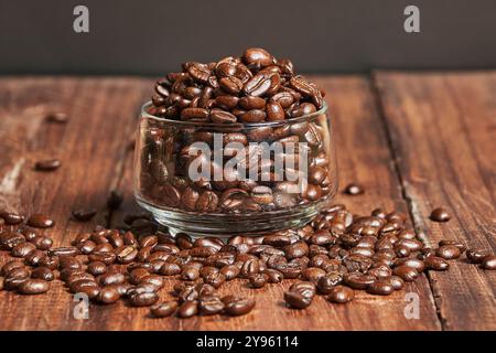 Nahaufnahme frisch gerösteter Kaffeebohnen in einem Glasbehälter auf einem alten Holztisch Stockfoto