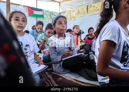 Gaza, Gaza, Palästina. September 2024. Die palästinensische Lehrerin Israa Abu Mustafa ergriff die Initiative, ein Klassenzimmer mit 30 Schülern in einem Zelt auf den Ruinen ihres zerstörten Hauses einzurichten, um Kinder zu unterrichten, wenn das neue Schuljahr beginnt und die Schüler aufgrund des Krieges nicht regelmäßig zur Schule gehen. Im Lager Khan Younis im südlichen Gazastreifen. (Kreditbild: © Saher Alghorra/ZUMA Press Wire) NUR REDAKTIONELLE VERWENDUNG! Nicht für kommerzielle ZWECKE! Stockfoto