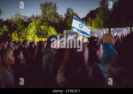 Toronto, Kanada. Oktober 2024. Während der Demonstration auf dem Sherman Campus wird eine israelische Flagge über einer Menschenmenge gehalten. Jüdische Gemeinden auf der ganzen Welt markierten den 7. Oktober, den tödlichsten Tag für das jüdische Volk seit dem Holocaust. Die UJA (United Jewish Appeal) Federation organisierte die Veranstaltung „7. Oktober: Marking One Year“ in Toronto, Kanada mit Gemeindemitgliedern, Verbündeten und Angehörigen von Geiseln, um Geschichten zu teilen, Kerzen anzuzünden und zusammen zu stehen, um die Ermordeten zu betrauern und die Überlebenden zu ehren. (Foto: Shawn Goldberg/SOPA Images/SIPA USA) Credit: SIPA USA/Alamy Live News Stockfoto