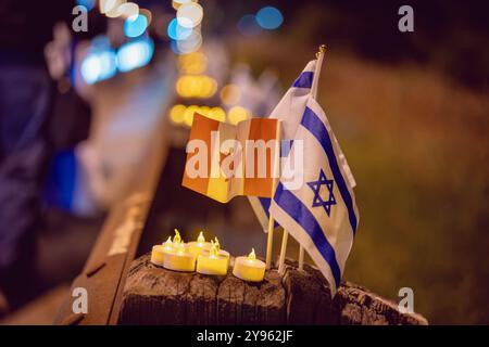 Toronto, Ontario, Kanada. Oktober 2024. Während der Demonstration auf dem Sherman Campus werden neben zündeten Kerzen auf einem Straßentrenner Flagge aus Israel und Kanada gesehen. Jüdische Gemeinden auf der ganzen Welt markierten den 7. Oktober, den tödlichsten Tag für das jüdische Volk seit dem Holocaust. Die UJA (United Jewish Appeal) Federation organisierte die Veranstaltung „7. Oktober: Marking One Year“ in Toronto, Kanada mit Gemeindemitgliedern, Verbündeten und Angehörigen von Geiseln, um Geschichten zu teilen, Kerzen anzuzünden und zusammen zu stehen, um die Ermordeten zu betrauern und die Überlebenden zu ehren. (Credit Image: © Shawn Goldberg/SOPA Images via ZUMA P Stockfoto